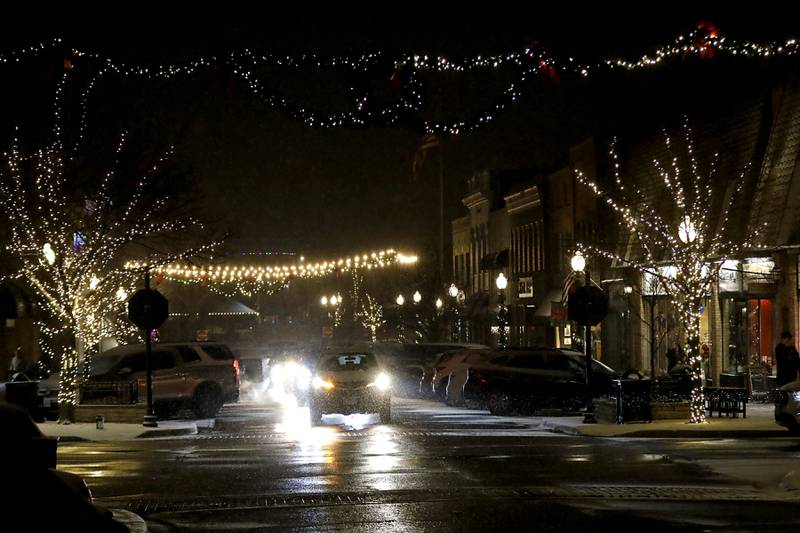 People drive through Crystal Lake's Luminary Nights on Thursday, Dec. 19, 2024, in downtown Crystal Lake. The snowy night featured sidewalks lite luminaries, holiday shopping and a visit to the Santa House.