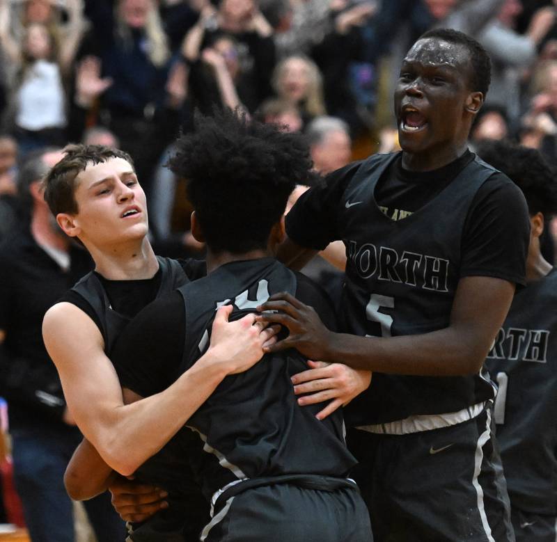 Glenbard North’s Jack Schager, left, celebrates with teammates JJ Hernandez, middle, and Josh Abushanab after he hit a buzzer-beater to win the game 44-43 over York during the final of the Addison Trail Sectional on Friday, March 1, 2024 in Addison.