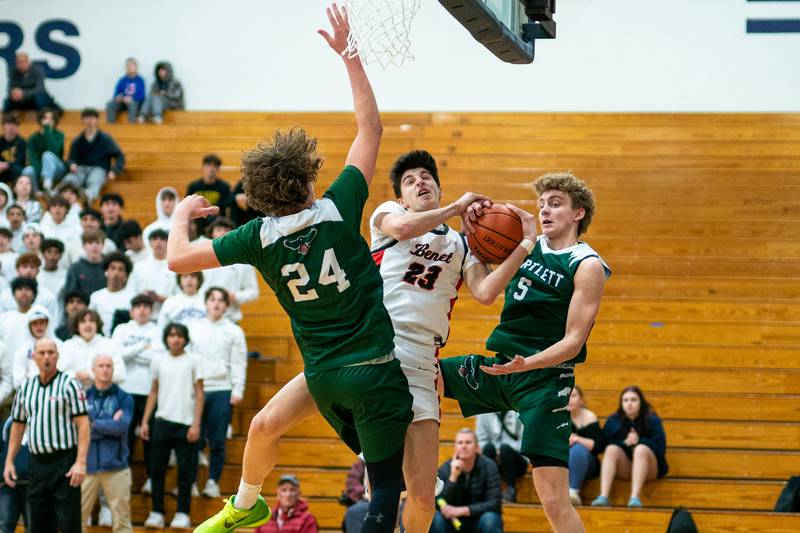 Benet’s Nikola Abusara (23) drives the hoop against Bartlett's Dimitre Petrasiunas (24) and Bartlett's Nathan Scearce (5) during the 4A Addison Trail Regional final at Addison Trail High School in Addison on Friday, Feb 24, 2023.