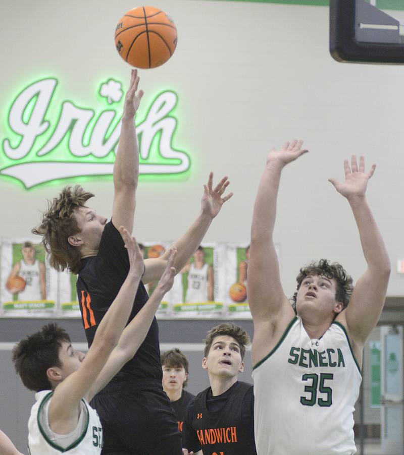 Sandwich’s Nick Michalek shoot over the blocks by Seneca’s James Zydron and Zeb Maxwell  in the 1st period Saturday during the MLK Shootout at Seneca.