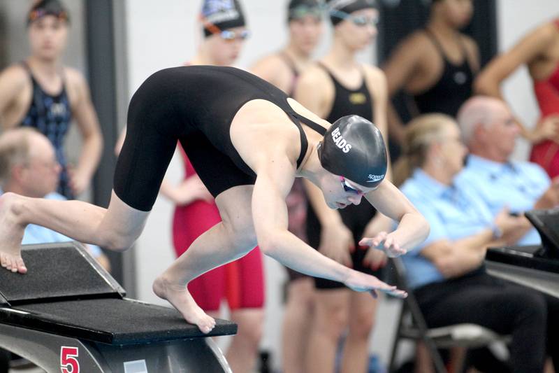 Rosary’s Olivia Moore takes off the block for the 50-yard freestyle during the IHSA Girls State Championships preliminaries at the FMC Natatorium in Westmont on Friday, Nov. 11, 2022.