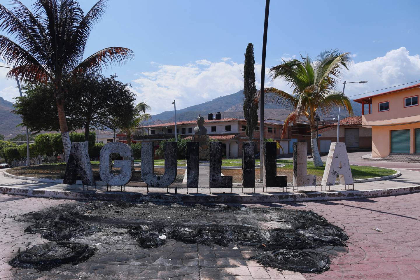 Letters spelling out the name of Aguililla, in Michoacan state, Mexico, stand burned, Tuesday, Feb. 24, 2026, after the Mexican army killed the leader of the Jalisco New Generation Cartel, Nemesio Oseguera Cervantes, known as "El Mencho." (AP Photo/Armando Solis)