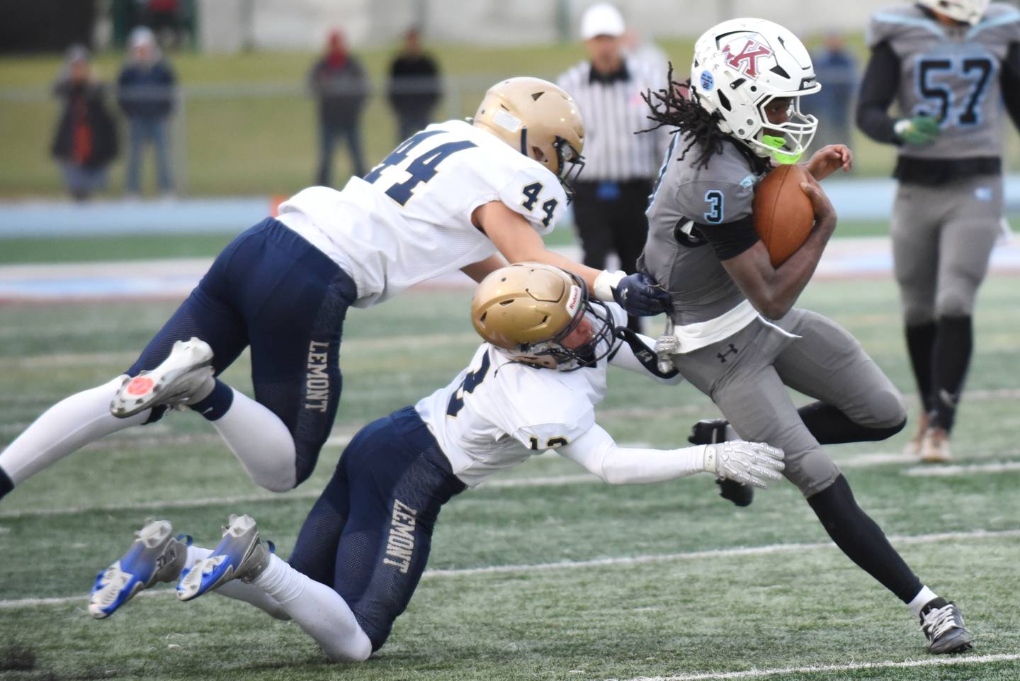 Kankakee's Cedric Terrell III, right, runs past a pair of Lemont defenders during an IHSA Class 5A playoff game at Kankakee Saturday, Nov. 1, 2025.