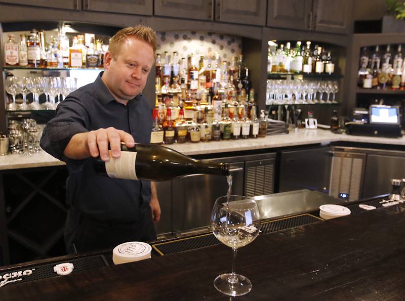 Erik Nordstrom, the wine and spirits director of 1776, pours a glass of wine at the farm to table restaurant in Crystal Lake on Thursday, April 11, 2024.