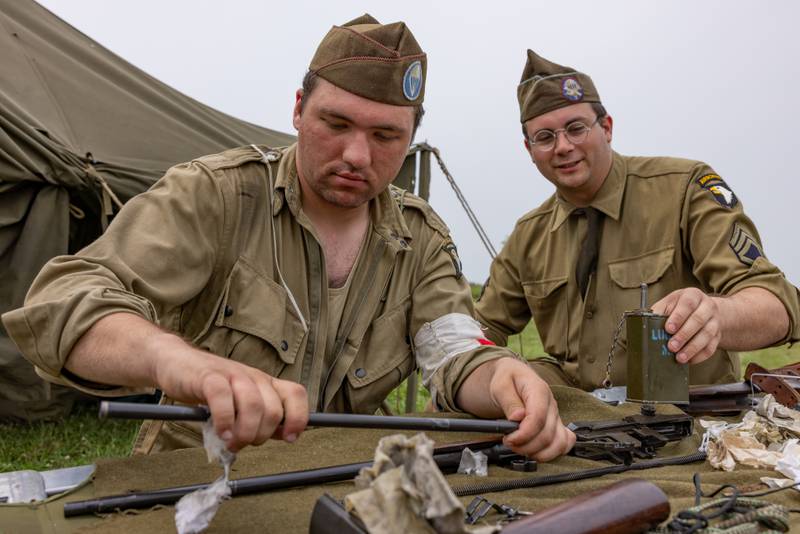 Jason Serdar (left) and Tyler Ahrendsen (right) work together to clean Serdar's M1 rifle after the demonstration battle at the Ottawa Military Show on July 13, 2025 in rural Ottawa.