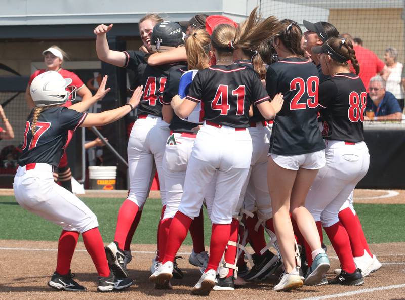 Members of the Benet Academy softball team gather behind home plate to celebrate winning the Class 3A State third place game over Charleston on Saturday, June 10, 2023 at the Louisville Slugger Sports Complex in Peoria.