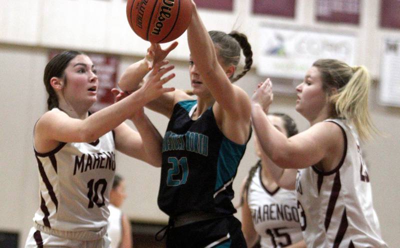 Marengo’s Bella Frohling, left, and Madison Cannon, right, pressure Woodstock North’s Isabella Borta in varsity girls basketball at Marengo Tuesday evening.