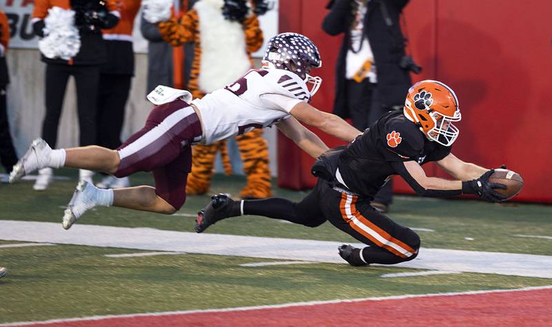 Byron’s Dawson Criddle dives for the end zone against Tolono-Unity's Keegan Germano Friday, Nov. 28, 2025, in the Class 3A football finals at Hancock Stadium at ISU.