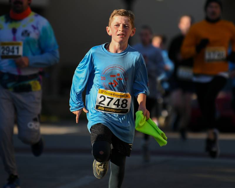 Rowan Nastal, 10, of Downers Grove runs in the Grove Express 5k race held in downtown Downers Grove on Thursday Nov. 23, 2023.