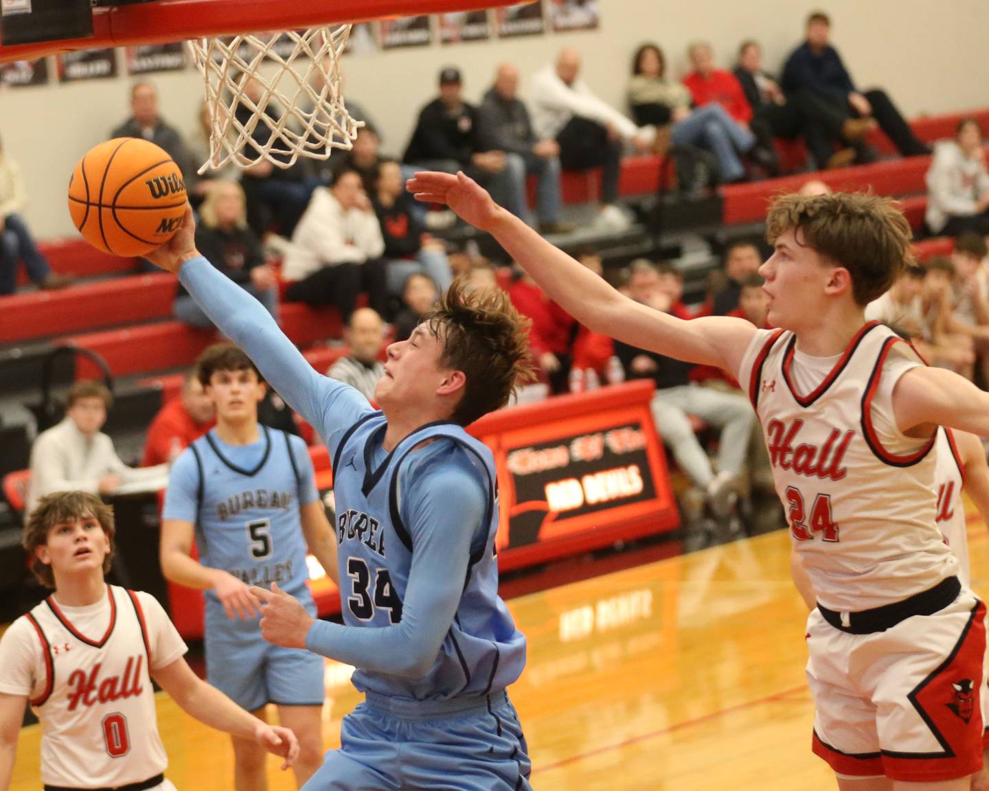 Bureau Valley's Carson Gruber does a reverse layup to score over Hall's Gage Olson on Wednesday, Jan. 28, 2026 at Hall High School.