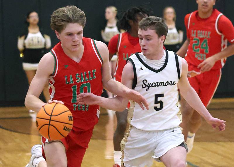 La Salle-Peru's Braylin Bond pushes the ball ahead of Sycamore's Preston Picolotti during their game Tuesday, Feb. 4, 2025, at Sycamore High School.