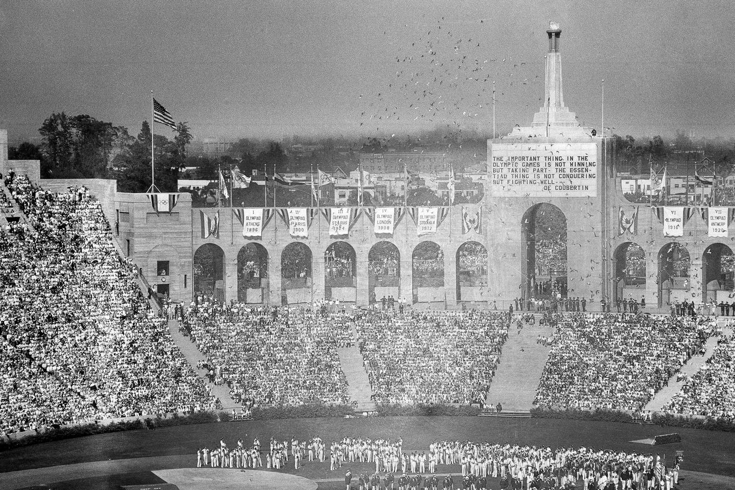 In this July 30, 1932, photo, doves are released during the opening ceremony for the Tenth Olympiad at Los Angeles. The athletes of various countries are shown on the field while the Olympic beacon and the entrance to the stadium is shown in the background.