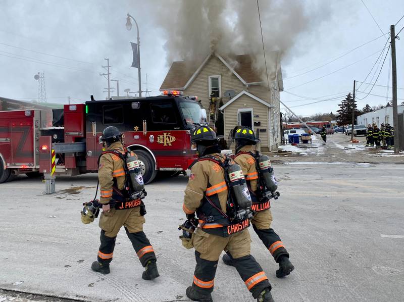 Sycamore firefighters walk toward a two-story duplex to help the emergency response on Saturday, Jan. 24, 2026, at Seventh Street and East Lincoln Highway downtown.