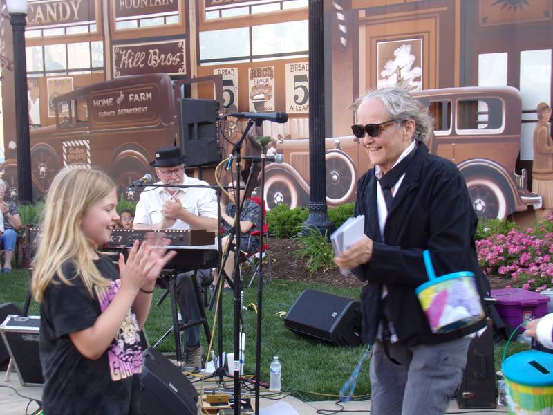 Jammin' at the Clock co-organizer Cinda Bond makes her way around the crowd Friday, June 2, 2023, collecting donations and passing out the season's schedule for the summer concert series.