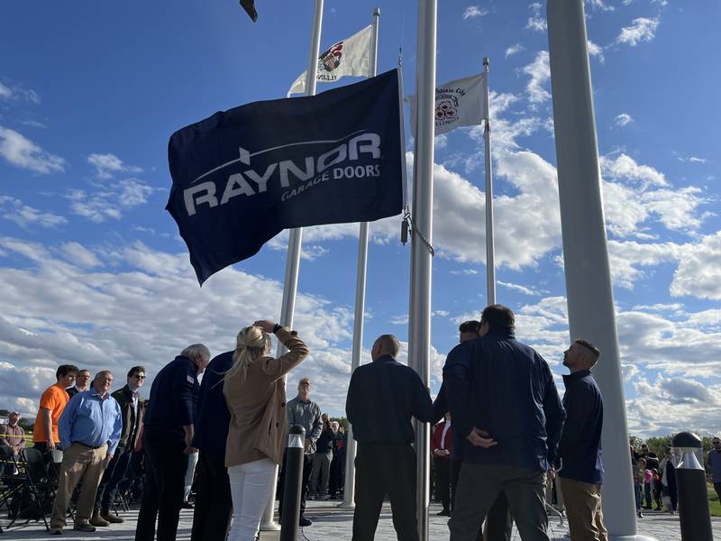 Smaller flags - one for Dixon,  the Local 790 carpenters union and Raynor Garage Doors - were also hoisted to surround the larger American flag at Raynor's event Thursday, May 22, 2025.