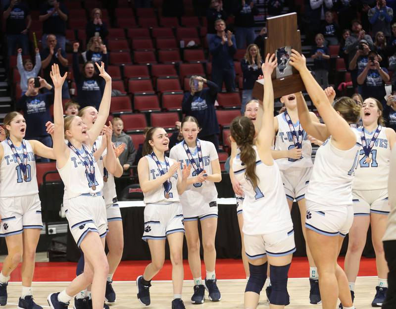 Members of the St. Edward girls basketball team hoist the Class 1A third place trophy on Friday, March 7, 2025 at CEFCU Arena in Normal.