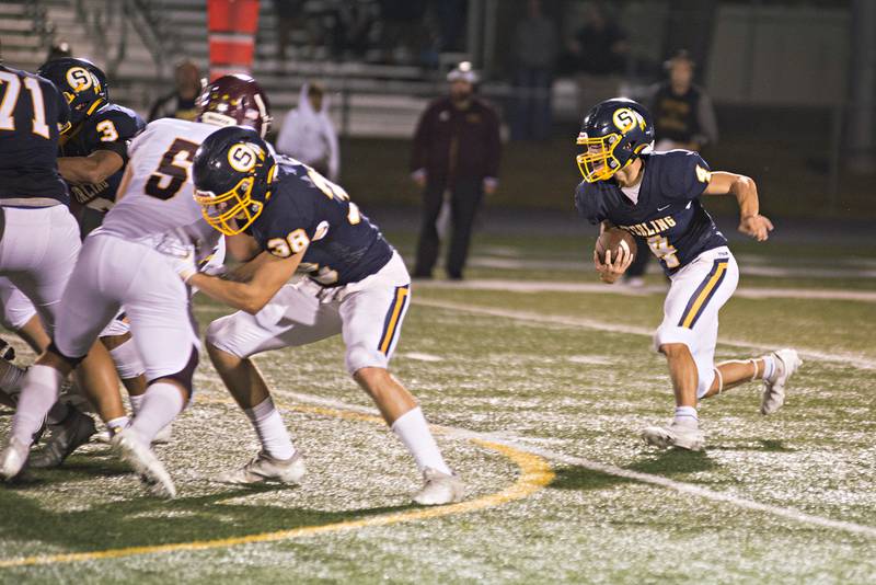 Sterling's Drew Kested takes the ball himself on a quarterback keeper Friday, September 3, 2021 against Montini.