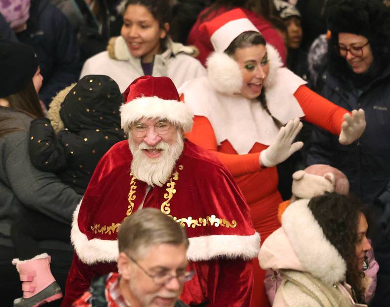 Santa and Elfie make their way through the crowd inside the Egyptian Theatre Thursday, Dec. 4, 2025, during the annual Lights on Lincoln and Santa Comes to Town event hosted by the DeKalb Chamber of Commerce.