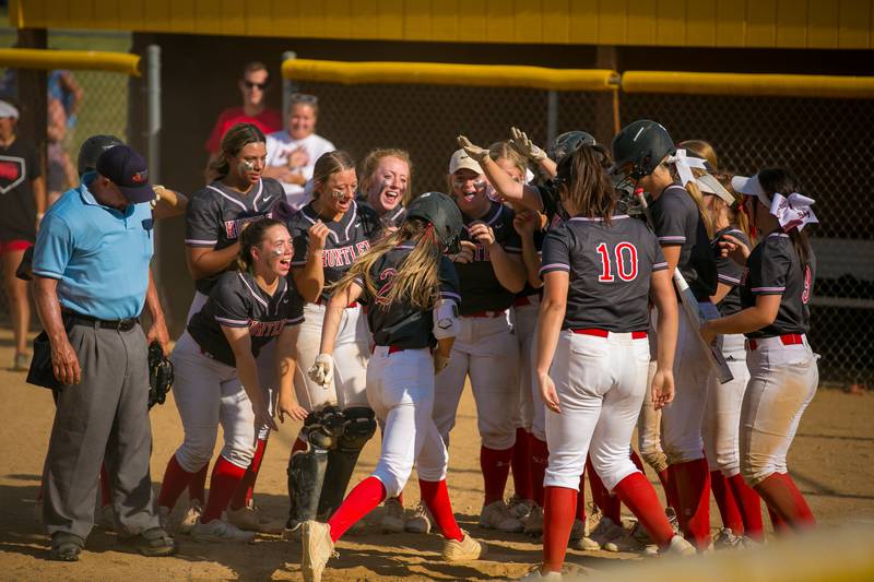 Huntley's Reese Hunkins (2) is met by teammates after hitting a home run in the fifth inning of the game at Harry D. Jacobs High School, Algonquin, Ill., on Tuesday, June 8, 2021. The Red Raiders won, 11-0 through 6 innings, and will host Harlem Thursday, June 10, in the Sectional Championship.