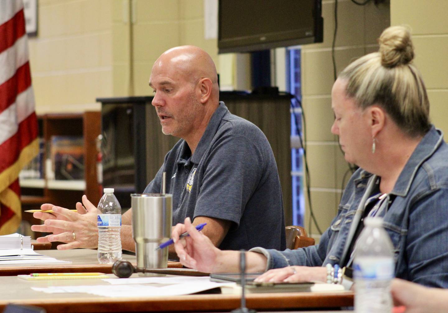 Sterling Public Schools Superintendent Tad Everett discusses the need for early dismissal once a week so groups of teachers can meet and serve the needs of underperforming students during a board of education meeting on Wednesday. Julie Aitken, serving as moderator, is at right.