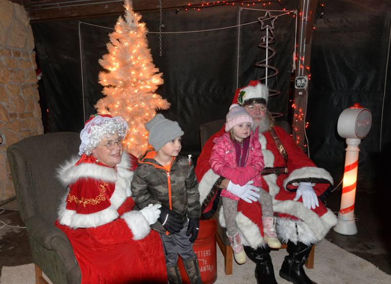 Santa and Mrs. Claus hold Charlotte, 3, and Tucker, 7, Crase of Forreston for a photo at Memorial Park during Christmas in the Country on Friday, Dec. 1, 2023.