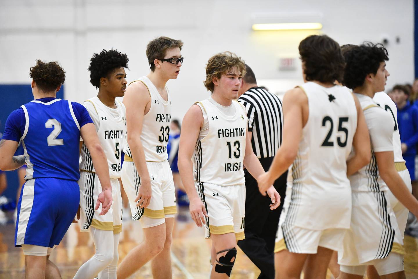 Bishop McNamara's Trey Provost (13), Callaghan O'Connor (33) and Willie Felton leave the court during the Fightin' Irish's 52-49 loss in the IHSA Class 2A Peotone Sectional championship on Friday, March 7, 2025.