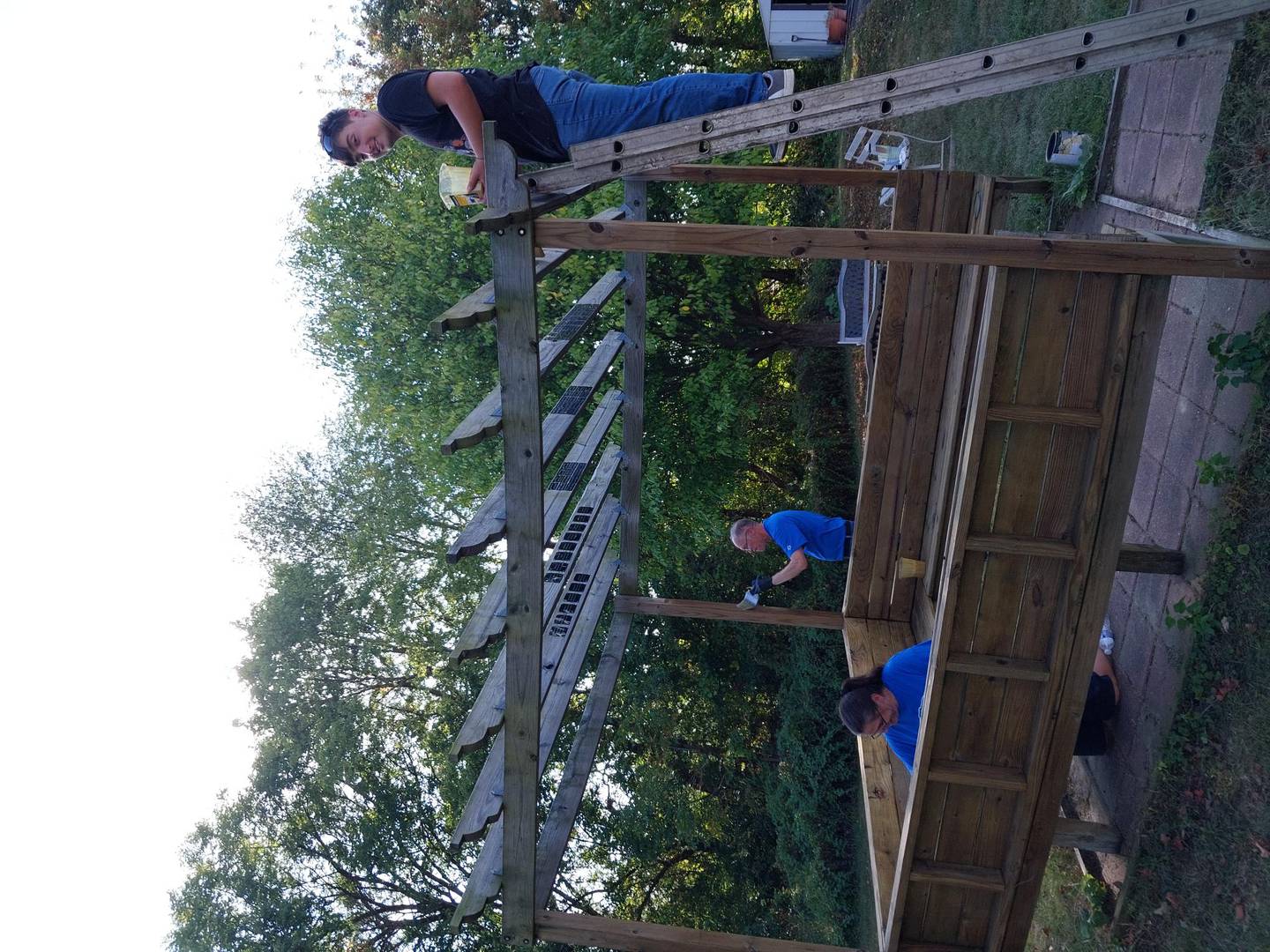 Walmart Team Lead Misty Karrow and William Healy and Misty's' son Zander Appleman are staining outdoor fixtures at Hope Cancer Wellness Center in Dixon.