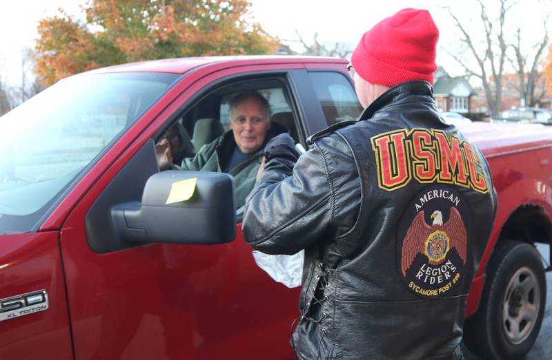 Volunteer James Brantley, a US Marine Corps veteran from DeKalb, hands a meal to a patron Friday, Nov. 11, 2022, during a Veterans Day drive-thru dinner event hosted by the DeKalb and Sycamore Elks Clubs at the Lincoln Inn at Faranda's. All veterans received free meals during the event.