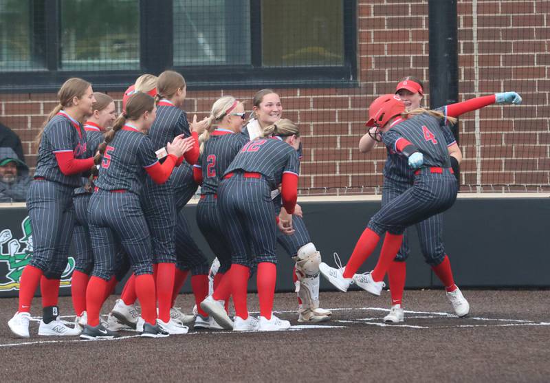 Ottawa's Teagan Darif (right) leaps in the air to jump on home plate while being greated by teammates after hitting her second home run on Friday, May 1, 2026 at Seneca High School.
