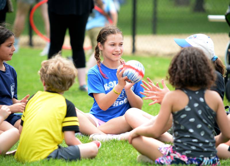 Children including Katrina Carmona of Oak Lawn play pass the potato during the Downers Grove Park District's 75th anniversary party at McCollum Park Saturday, May 14, 2022.