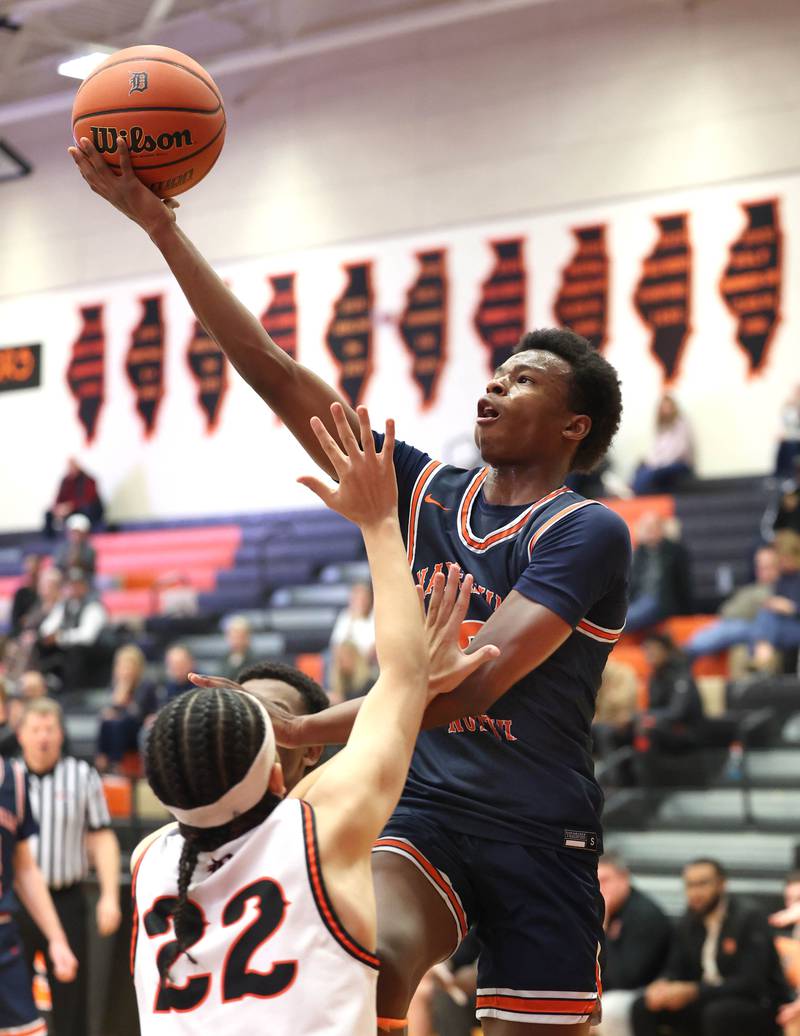 Naperville North's Bryce Welch shoots over DeKalb’s Unique Shaw during their game Friday, Dec. 8, 2023, at DeKalb High School.