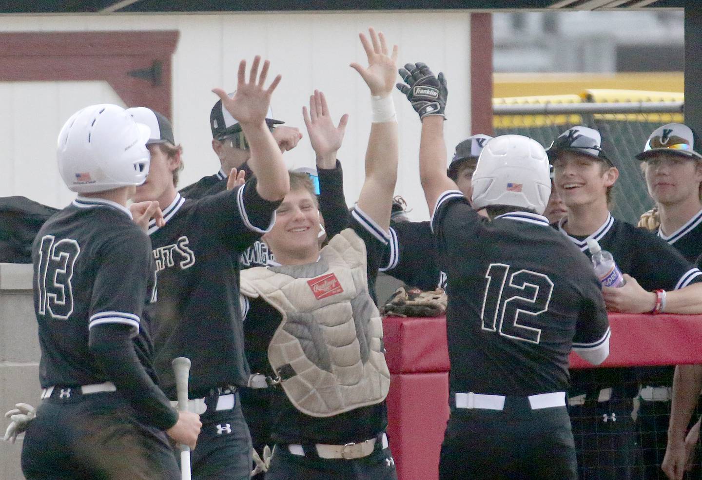 Members of the Kaneland baseball team hi-five teammates Preston Popovich and Anthony Campise after scoring a pair of runs against L-P on Thursday, April 11, 2024 at Huby Sarver Field in La Salle.