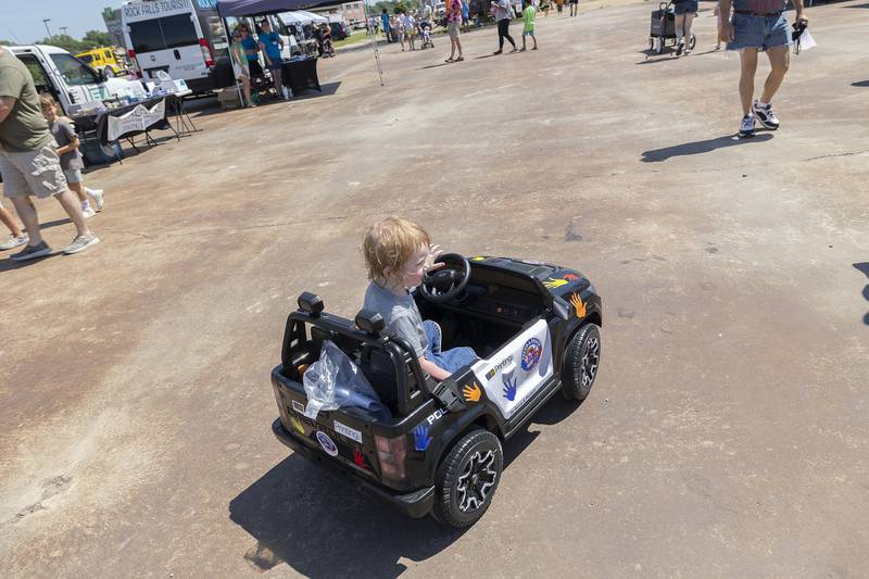 Teddy Mattingly, 2, of Rock Falls cruises around in a toy police car Saturday, June 28, 2025, at the Touch-a-Truck event.
