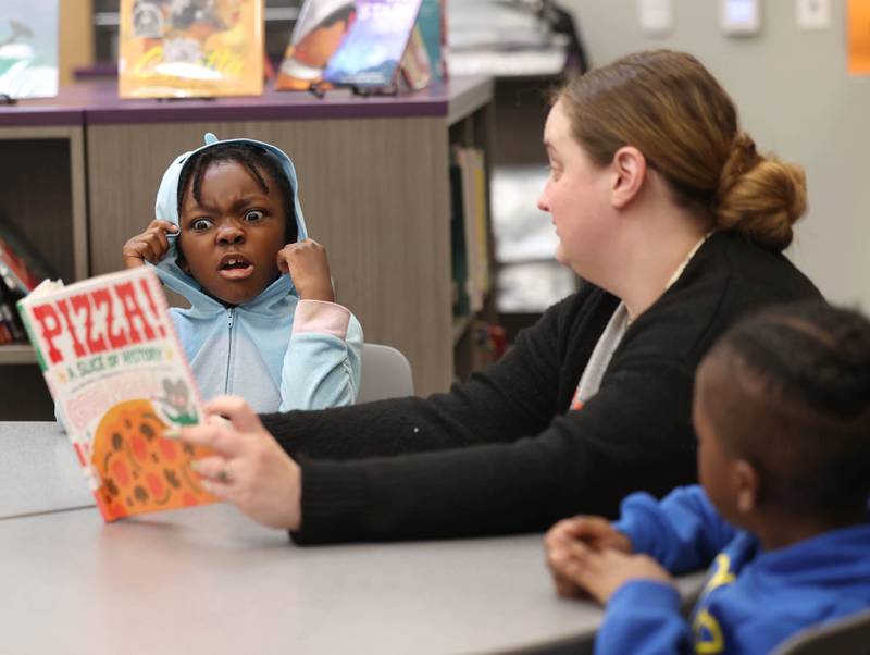 Mitchell Elementary School first grader Savannah Holden reacts as teacher Cassandra Sprankle reads a book about pizza Thursday, March 19, 2026, in the library at the school in DeKalb.