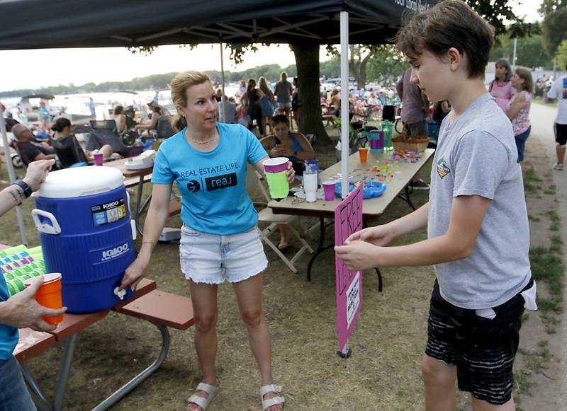 Erin Matthews, of Gassensmith Group, serves free lemonade during the Crystal Lake Park District's Concert in the Park on Tuesday, June 17, 2025, at Main Beach in Crystal Lake. The concert was part of the park district's weekly Tuesday night summer concert series.