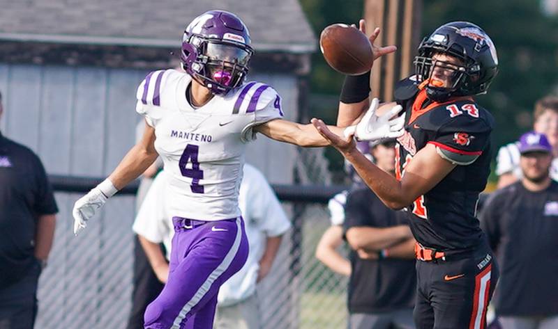 Sandwich’s Caleb Jones (14) intercepts a pass intended for Manteno's Kyle Mc Cullough (4) and runs it back for a touchdown against Manteno during a football game at Sandwich High School on Saturday, Aug 26, 2023.