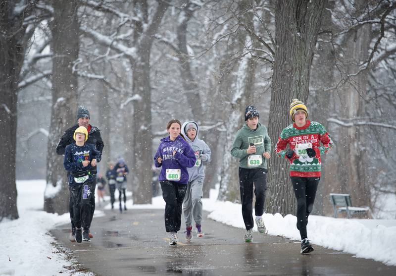 Runners in the 35th annual Jingle Bell Run run along the river at Kankakee Community College on Sunday, December 7, 2025.