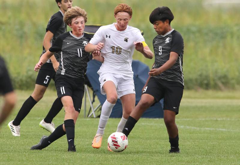 Kaneland's Matthew Mitchinson (left) and Abe Paulino (right) try to gain possession from Sycamore's Jameson Carl during their game Wednesday, Sept. 6, 2023, at Kaneland High School in Maple Park.