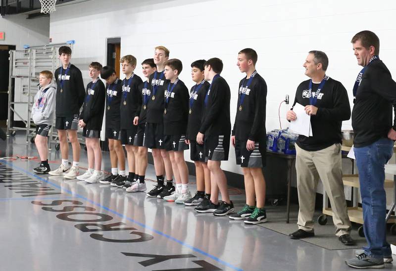 Members of the Mendota Holy Cross eighth-grade boys basketball team enter the gymnasium for a reception on Tuesday, Feb. 20, 2024 at Holy Cross School. The team beat Pana Sacred Heart 41-33 to win the IESA Class 1A State championship.