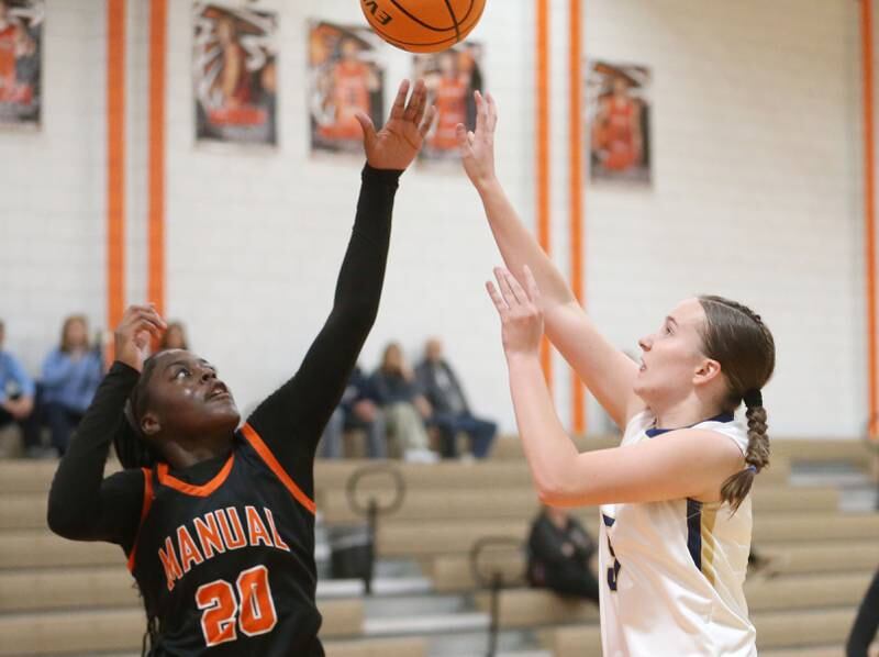 Marquette's Chloe Larson pulls up in the lane to shoot a shot over Manual's Breyasia Grayson during the Falcon-Irish Thanksgiving Tournament on Monday, Nov. 18, 2024 at Flanagan High School.