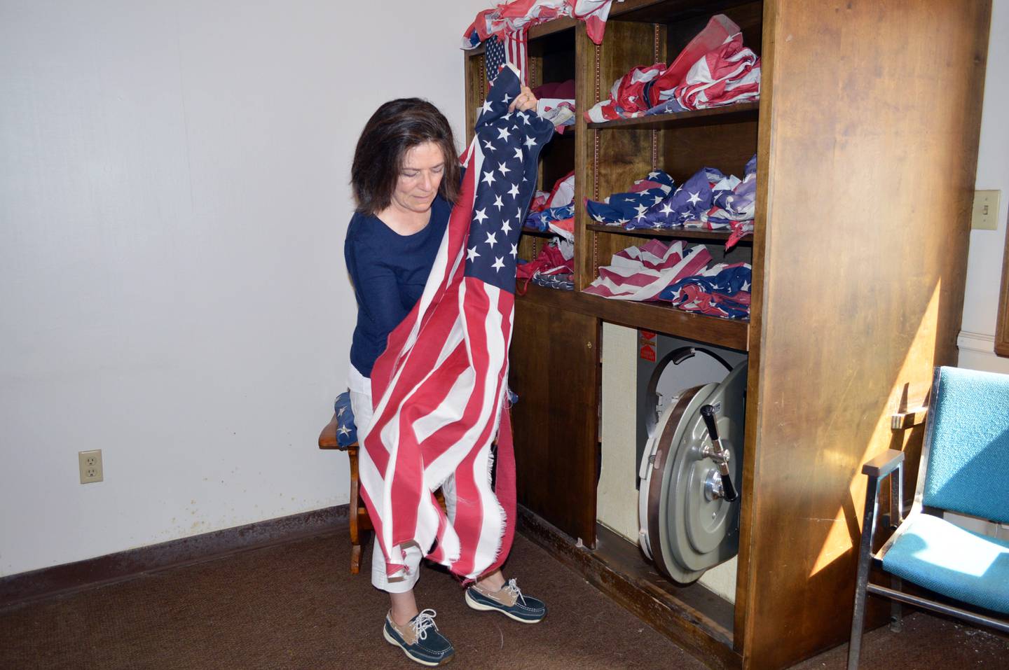 Polo's Patrick Fegan American Legion Post No. 83 Past Commander Cynthia Reynolds on Saturday, Sept. 28, 2024, holds a tattered American flag, one of many that was dropped off at 101 W. Mason St., Polo, for proper disposal. The flags that are cotton will be ceremonially burned; the others will be given to local funeral homes to be cremated with veterans as part of the Legion's new Farewell Flags program.