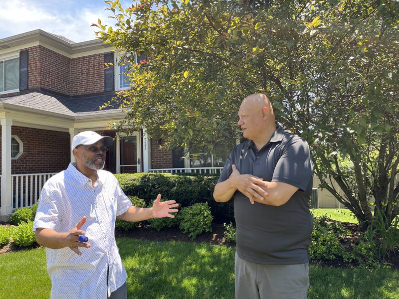 Tab Martin (left) speaking with Antonio Rivera outside of their homes on Thursday, June 30, 2022 in Bolingbrook.