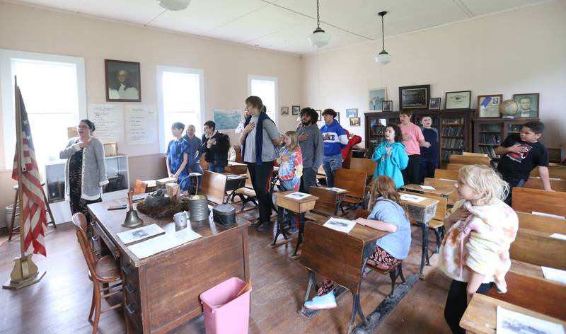 Museum Director Amanda Carter recites the Pledge of Allegiance with Bureau County Special Schools BEST Program students, on Tuesday, May 20, 2025, at the La Salle County Historical Society's one-room schoolhouse in Utica.