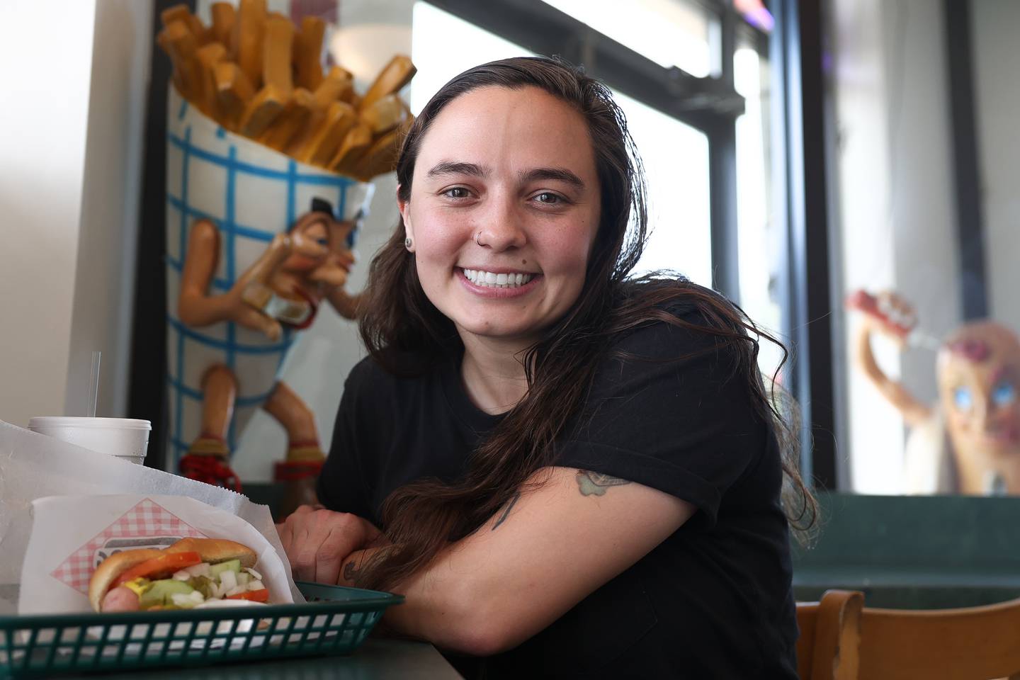 Sincere Engineer lead singer Deanna Belos, a Homer Glen resident, poses for a photo in one of her favorite fast food spots Don’s Hot Dogs on Wednesday, Aug. 2.