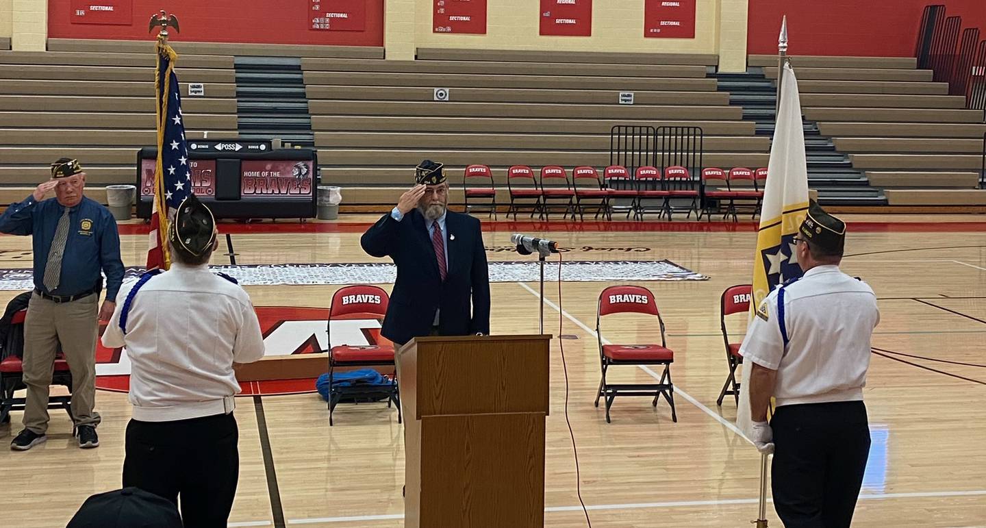 Commander Gerald J. Zeborowski of the VFW Post 6049 (left) and Commander of the Morris American Legion Ken Buck (center) stand at attention for the Posting of the Colors during the Veterans Day ceremony on Nov.11.