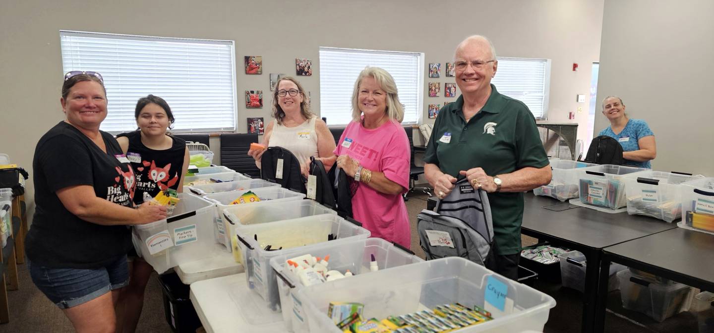 Volunteers and organizers with Big Hearts of Fox Valley fill backpacks with school supplies for donation during a packing event on Aug. 7, 2025.
