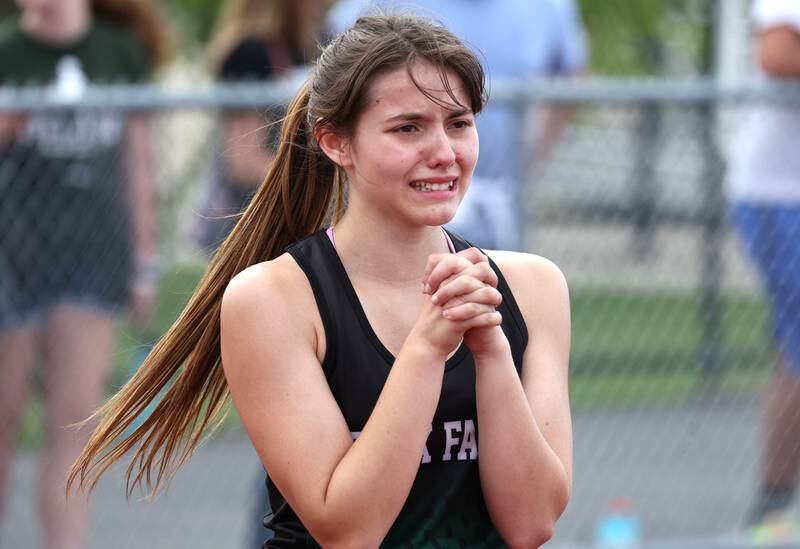 Rock Falls’ Hana Ford prays that her team qualifies as she watches the finish of the 4x800 relay Wednesday, May 8, 2024, during the girls track Class 2A sectional at Rochelle High School.