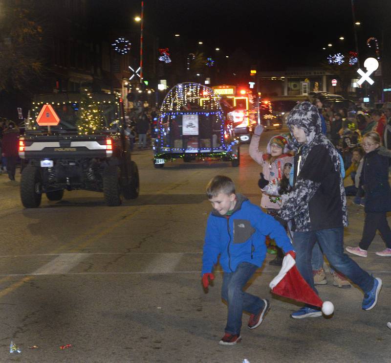 Children race for the candy treats tossed their way Saturday along Main St during the annual Holiday Magic Lighted Santa Parade in Marseilles.