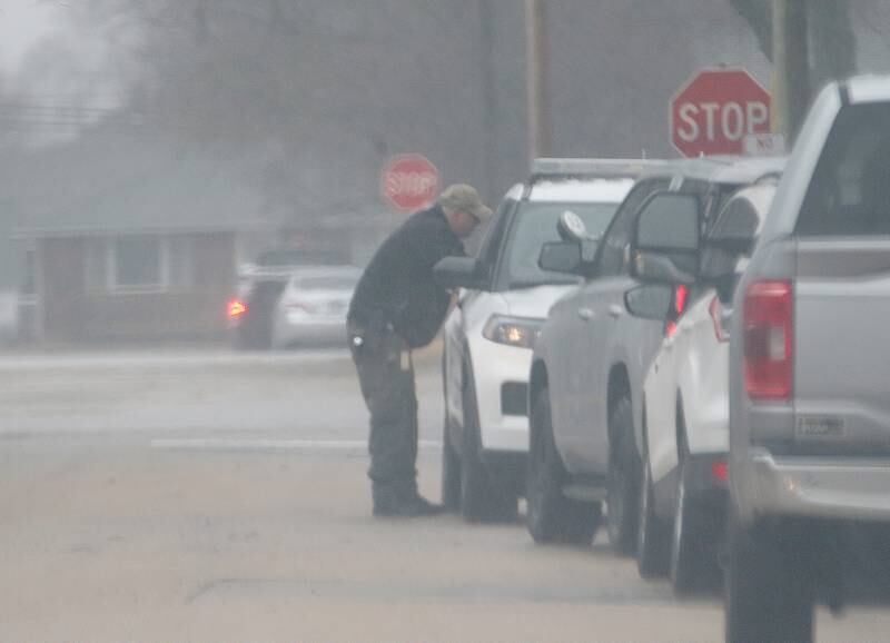 A police officer talks with other law enforcement outside a home in the 1100 block of East Elm Street on Tuesday, March 4, 2025 in Streator.