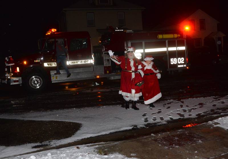 Santa and Mrs. Claus wave to the crowd as they disembark a Forreston firetruck at Memorial Park en route to talking to kids during Christmas in the Country on Friday, Dec. 1, 2023.
